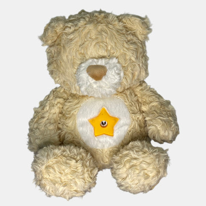 Beige teddy bear with a white heart and yellow star on a light gray background