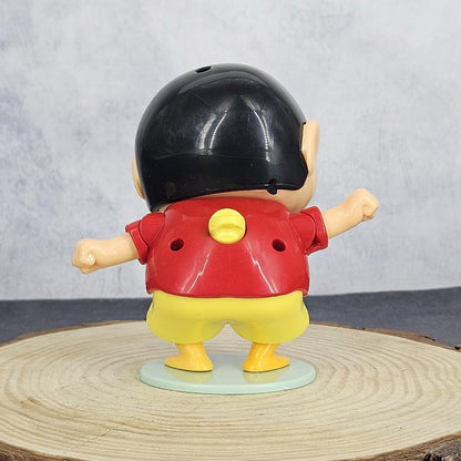 Toy figure with a black helmet, red shirt, and yellow shorts on a wooden surface.
